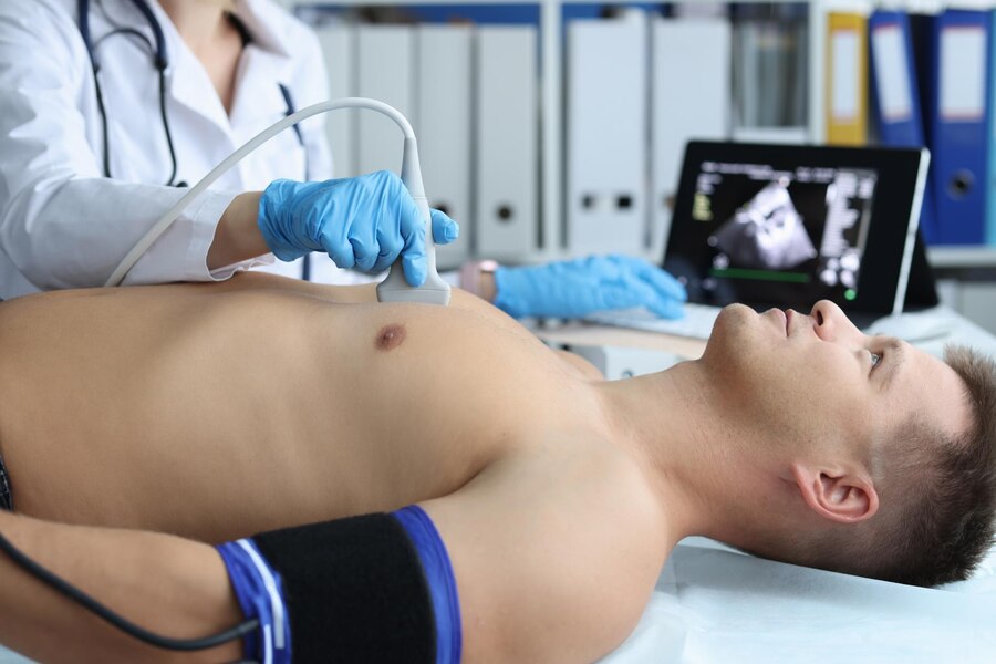 Doctor places ultrasound probe on chest of male patient