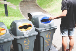 A man putting garbage in mini skip hire Manchester