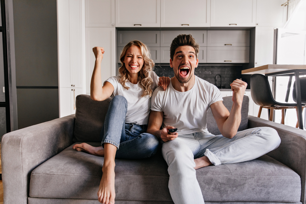 Laughing couple watching TV