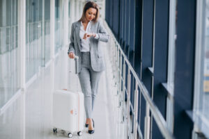 Business woman with travel bag in airport waiting for a flight